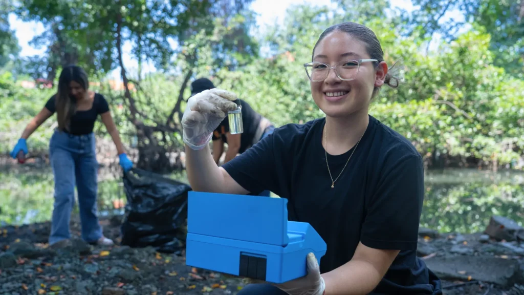 Estudiantes de ECOTEC tomando muestras de agua en un estero