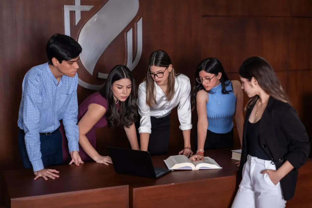 Estudiantes revisando documentos en estrado