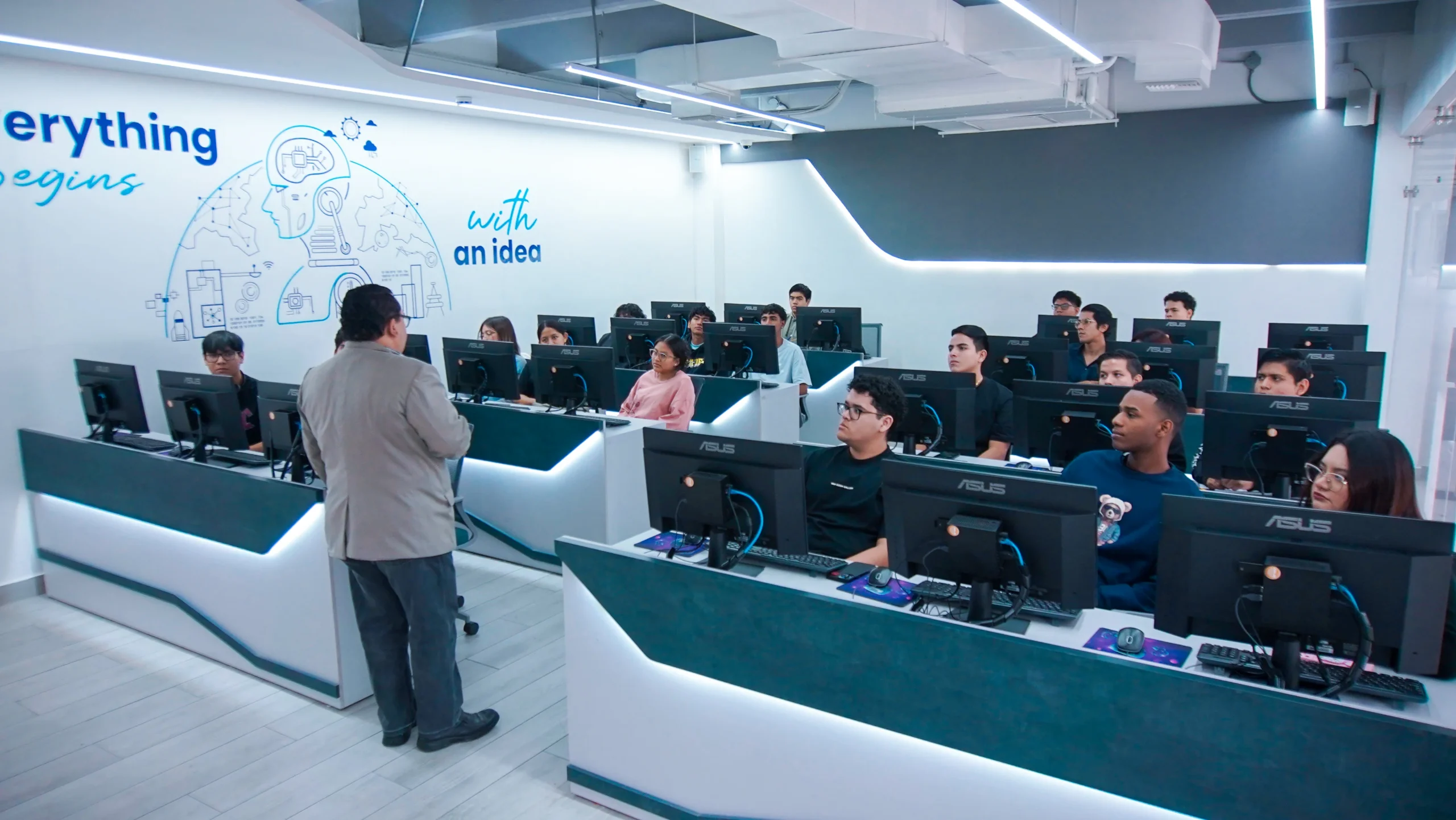 Docente dicta clase a estudiantes en un laboratorio de computación de ECOTEC