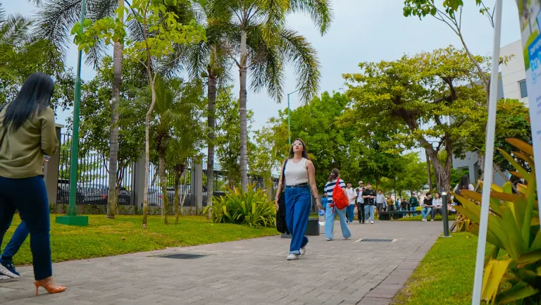 Estudiantes caminando por las áreas verdes del campus de la Universidad ECOTEC
