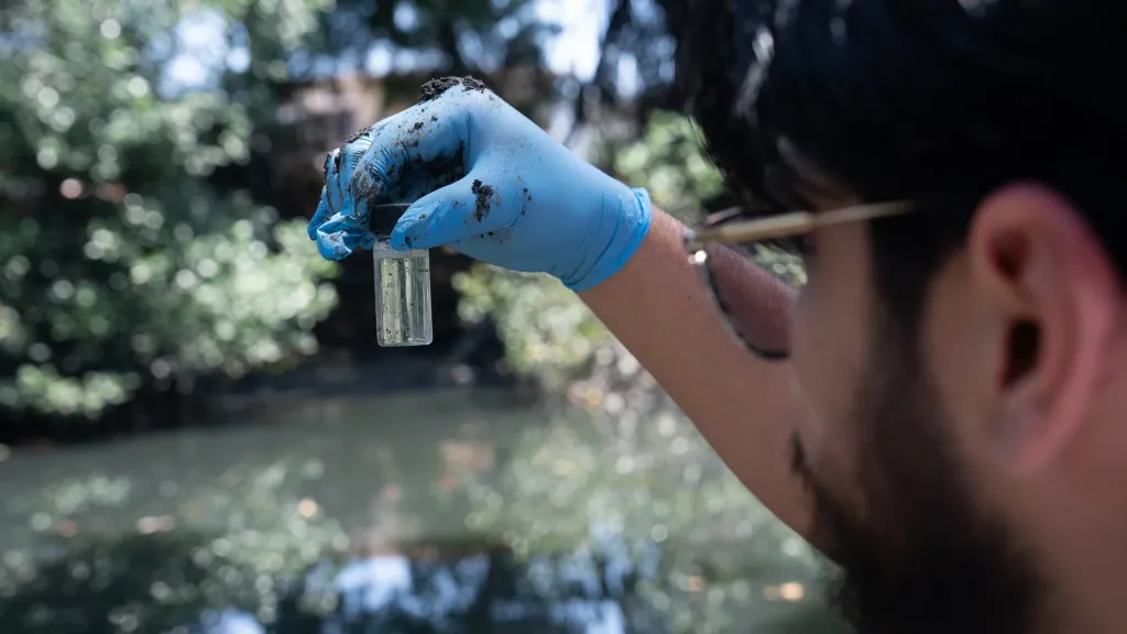 Investigador de la Universidad ECOTEC observa una muestra de agua tomada del estero