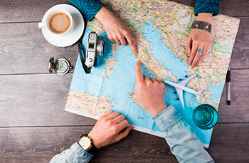 Manos sobre un mapa planificando un viaje de estudios al extranjero